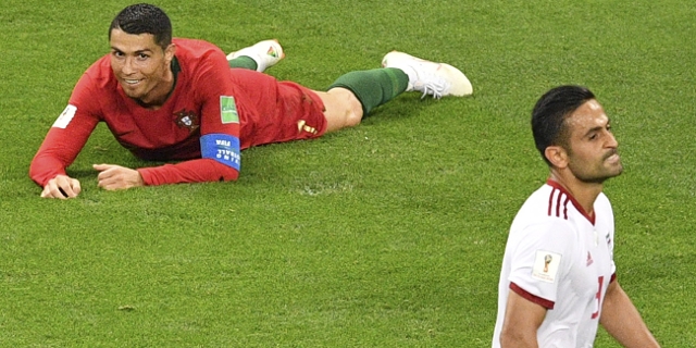 Ronaldo (Portugal) am Boden hinter Iran-Spieler
