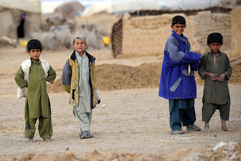 Afghanische Kinder auf einer staubigen Straße