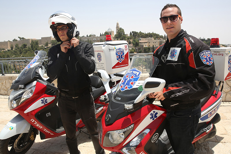 Zwei Mitarbeiter von United Hatzalah mit roten Motorrädern