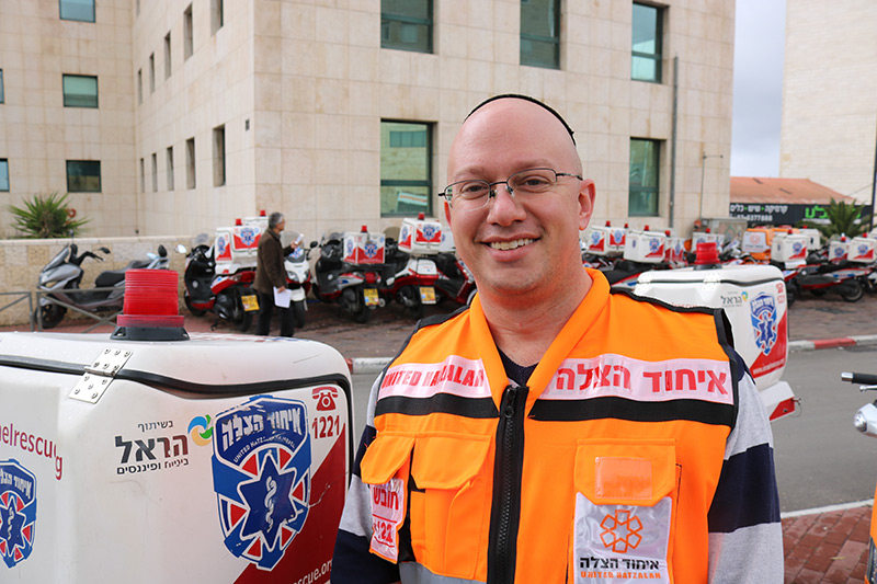 Mitarbeiter von United Hatzalah in orangefarbiger Warnweste