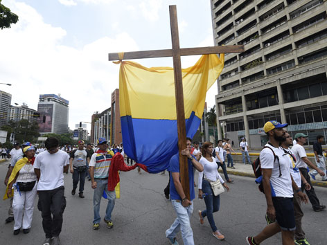 Demonstranten in Venezuela mit einem Holzkreuz in der Hand