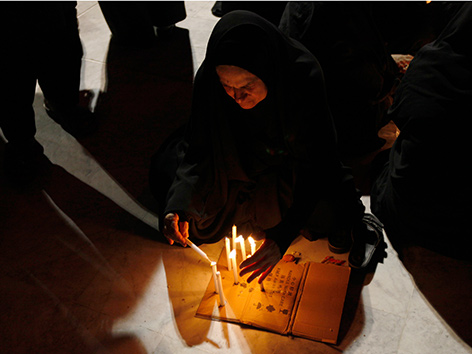 Eine irakische Schiitin zündet Kerzen zu Aschura