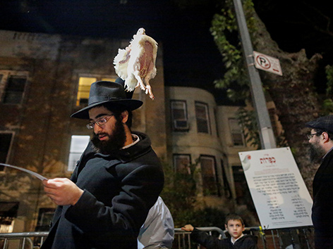 Ein orthodoxer Jude hält beim Kapparot-Ritual ein Huhn über seinen Kopf