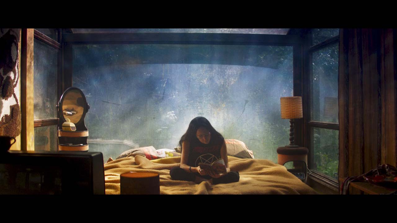 Filmstill Mandy: Frau sitzt auf einem Bett und liest