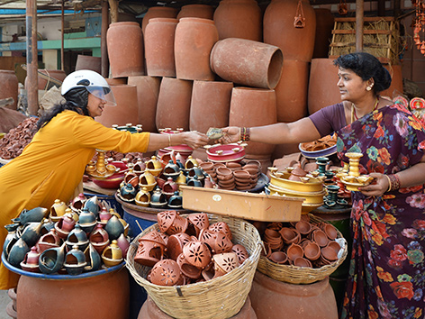 Eine Frau kauft Öllampen bei einem Marktstand