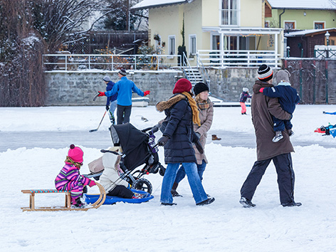 Eine Familie mit kleinen Kindern und Schlitten im Winter an der Alten Donau