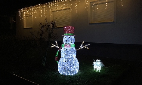 LED-Schneemann und Lichterkette in einem Garten