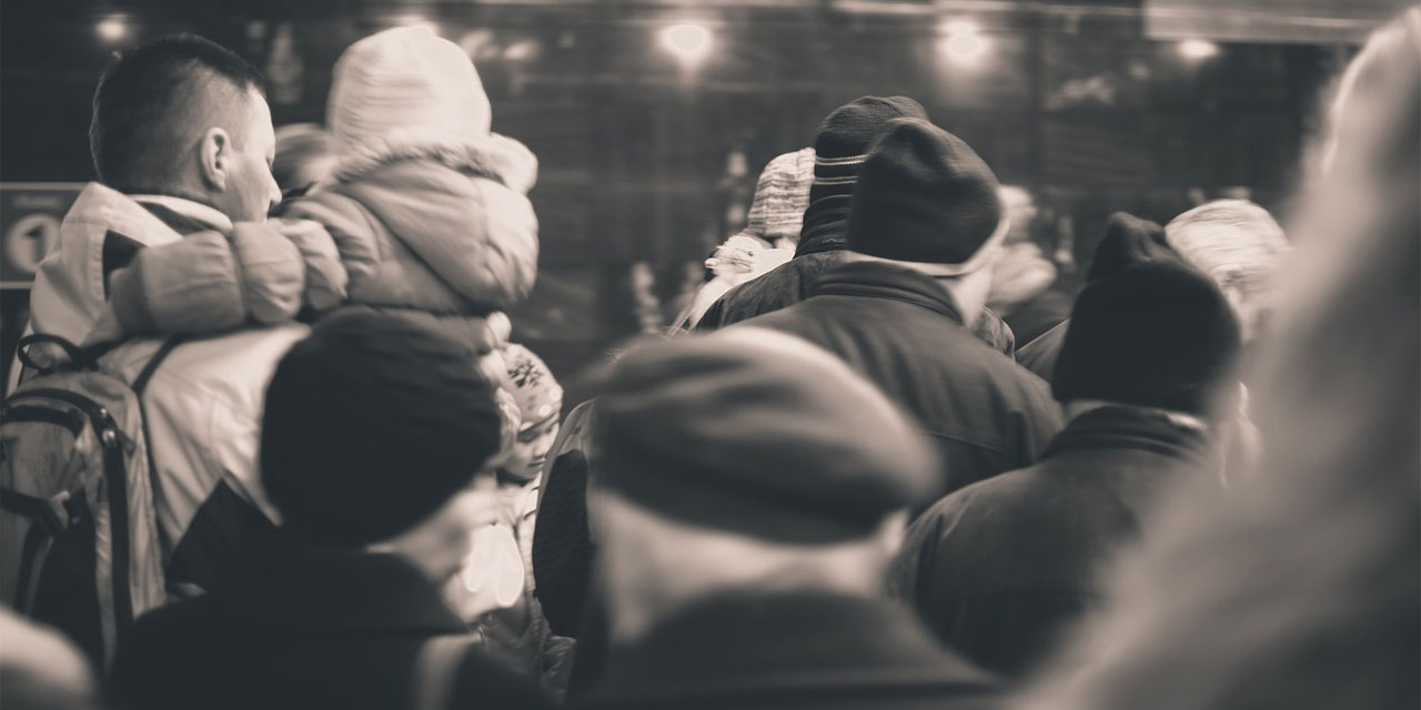 Menschen in winterlicher Bekleidung in einer U-Bahn