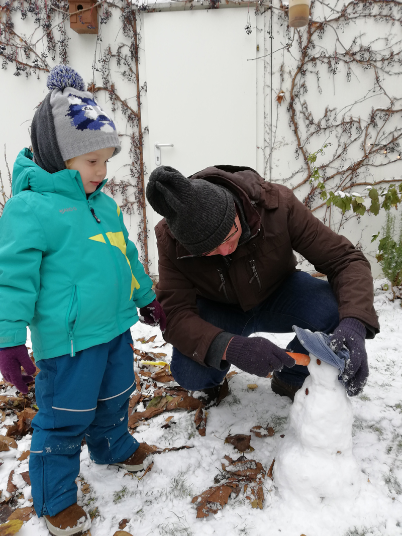 Gregor Johannssón und sein Sohn beim Schneemann bauen