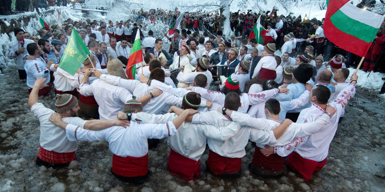 Bulgarische Männer tanzen im Eiswasser
