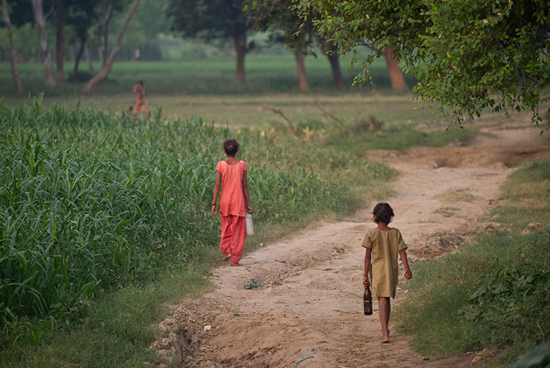 Kinde in Indien gehen entlang eines Feldweges