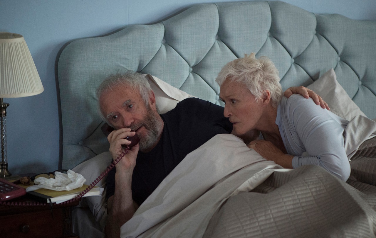 Glenn Close und Jonathan Pryce als Joan und Joe Castleman im Bett liegend, einen Anruf erhaltend