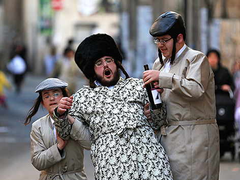 Wein trinkende ultraorthodoxe Juden auf einer Straße in Mea Shearim, Jerusalem