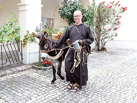 Ein Kapuziner aus dem Kloster Wiener Neustadt mit einem Esel
