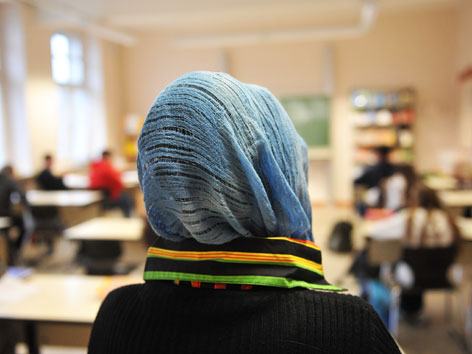 Eine Schülerin mit Kopftuch im Klassenzimmer