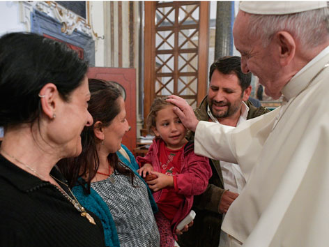 Papst Franziskus segnet ein Roma-Mädchen. Er zeigte sich damit solidarisch mit einer Roma-Familie, die Anfeindungen ausgesetzt ist.