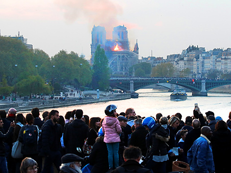 Menschen beobachten die brennende Kathedrale Notre-Dame de Paris