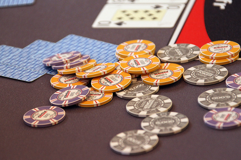 Geldjetons und Pokerkarten auf einem Spieltisch