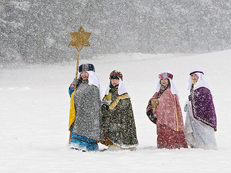 Als Heilige Drei Könige und Sternträger verkleidete Kinder stapfen durch den Schnee in Waldzell (OÖ) - Jänner 2019