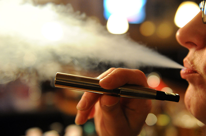 Dampf: Eine Frau hält eine elektrische Zigarette