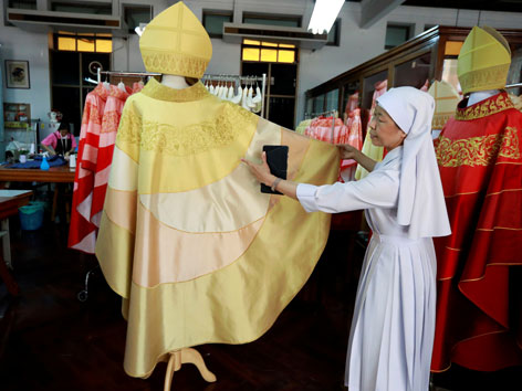 Eine weiß gekleidete Ordensfrau zeigt das thailändische Gewand für Papst Franziskus