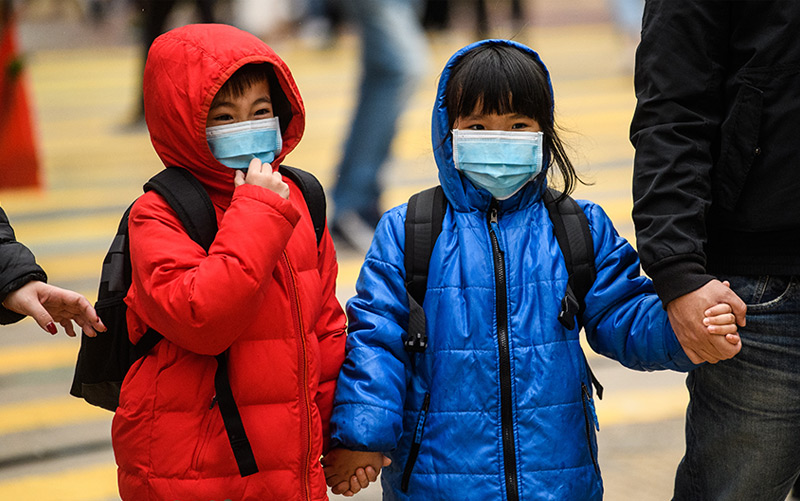 Kleine Kinder tragen in Hongkong Schutzmasken gegen das Coronavirus