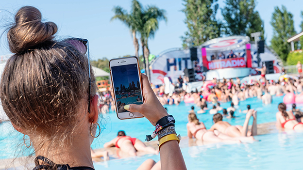 Frau fotografiert mit ihrem Handy die Bühne beim Summer Splash
