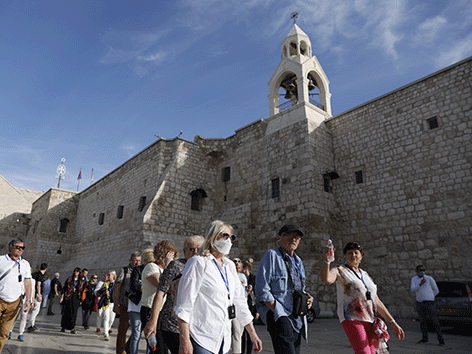 Menschen teilweise mit Schutzmasken vor der Geburtskirche in Bethlehem