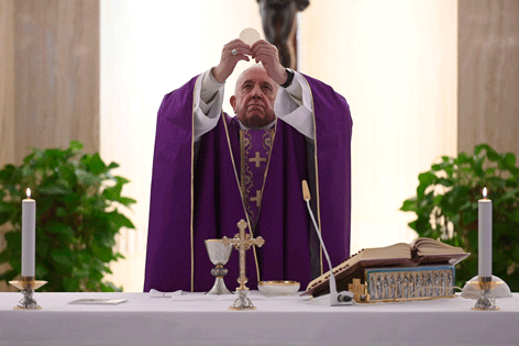 Papst Franziskus, mit Hostie, feiert eine Messe - allein - in Zeiten von Corona,