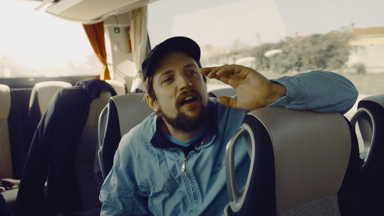 Robin sitzt in einem Reisebus und ruft seiner Mannschaft etwas zu. Szene aus der Dokumentation "Robin's Hood".