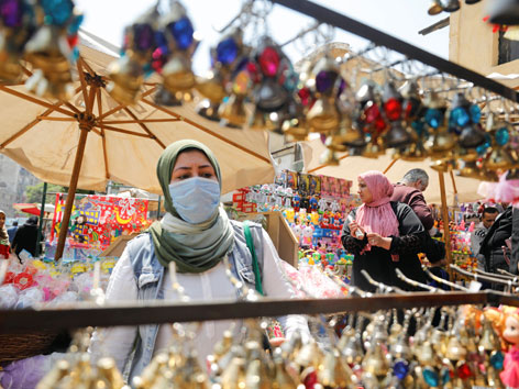 Eine muslimische Frau mit Mundschutz auf einem Markt in Kairo