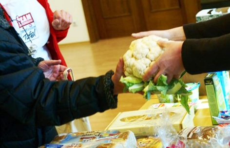 Team Österreich Tafel - Mitglied übergibt einen Blumenkohl bei der Essensübergabe