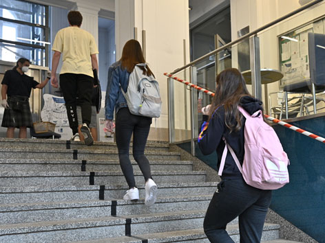 Oberstufen-Schülerinnen gehen Stufen zum Schulgebäude hinauf