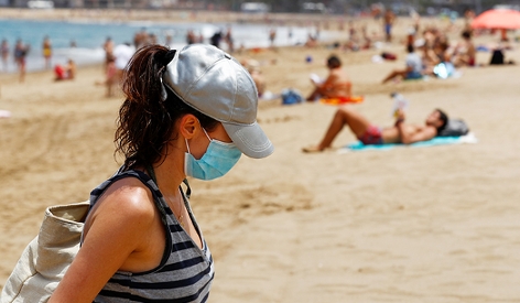 Frau mit Maske am Strand