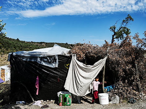 Ein Bub vor einem selbstgebauten Zelt nahe des Flüchtlingslagers Moria