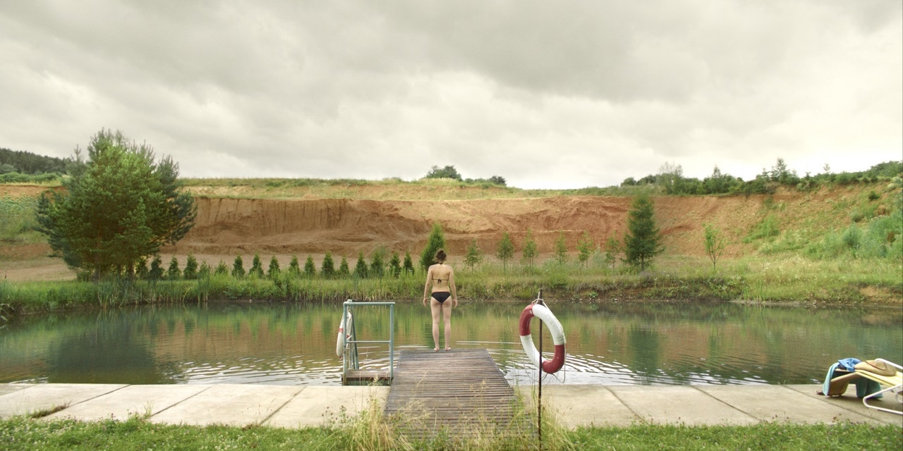 Ein Mädchen steht an einem Badeteich, Filmszene aus "Siebzehn"