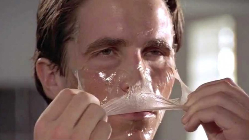 Christian Bale als Patrick Bateman zieht sich eine Peel-off-Maske vom Gesicht