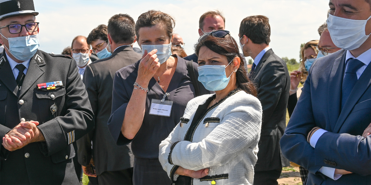 Britain's Home Secretary Priti Patel (C) and French Interior Minister Gerald Darmanin (R), wearing face masks, look at French police equipment during their visit in Calais on July 12, 2020.