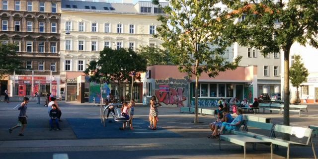 Volkertplatz: Menschen sitzen auf Bänken