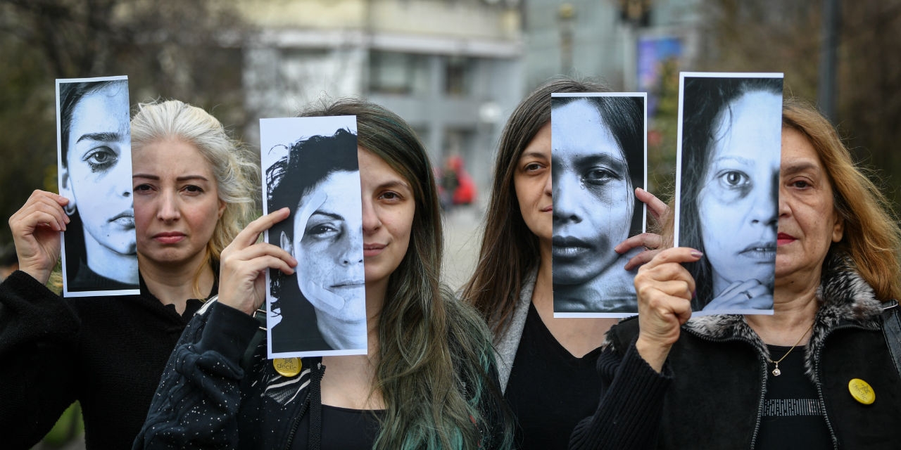 Frauen halten bei einer Demonstration Fotos von Opfern häuslicher Gewalt