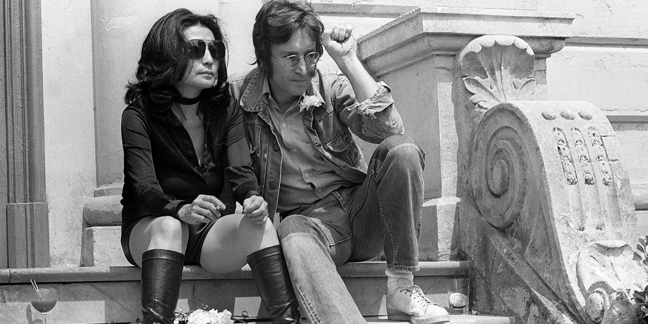 1971: John Lennon und seine Frau Yoko Ono sitzen auf einer Stiege