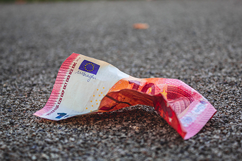 Eine zerknitterte Euro-Banknote am Boden