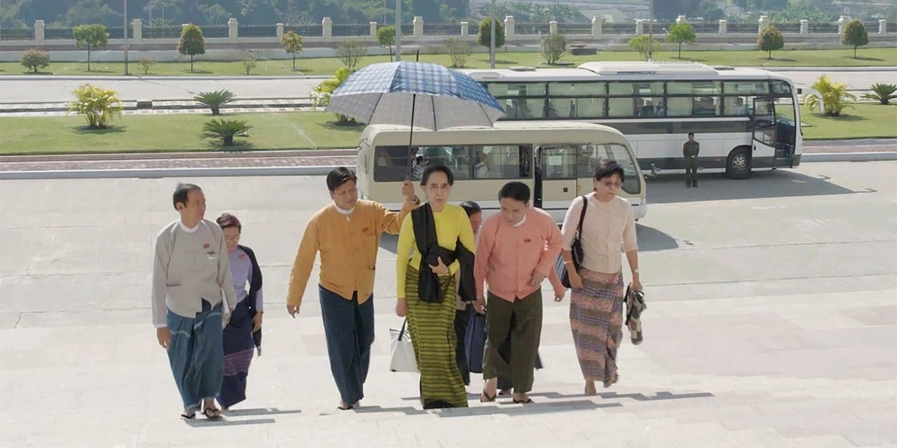 Suu Kyi erscheint mit Begleitern vor dem Parlamentsgebäude. Filmstill aus "On the inside of a military dictatorship".