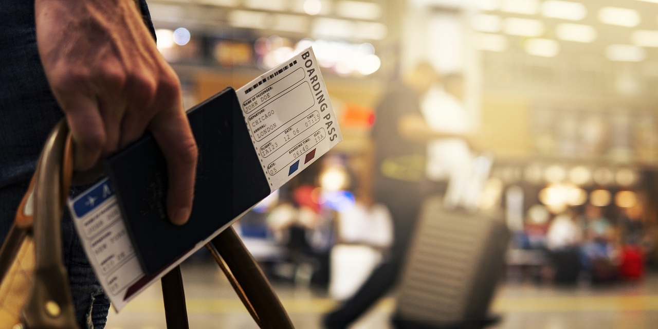 Reisepass und Boarding Pass in einer Hand gehalten