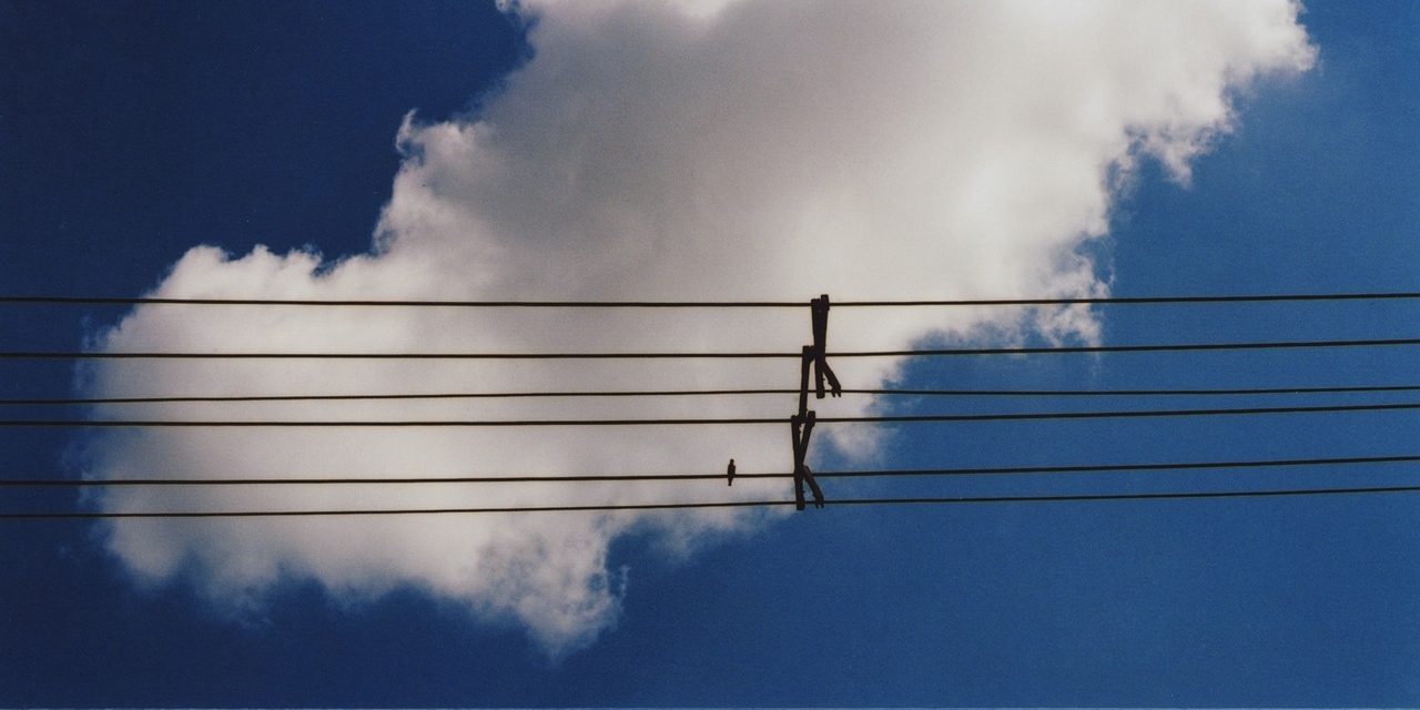 Kabel vor blauem Himmel mit weißer Wolke