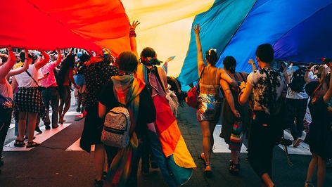 Menschen unter einer Regenbogenflagge