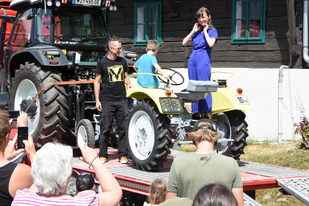 Ankunft des Traktors, viele Bekannte sind am Hof zusammengekommen für ein Fest.