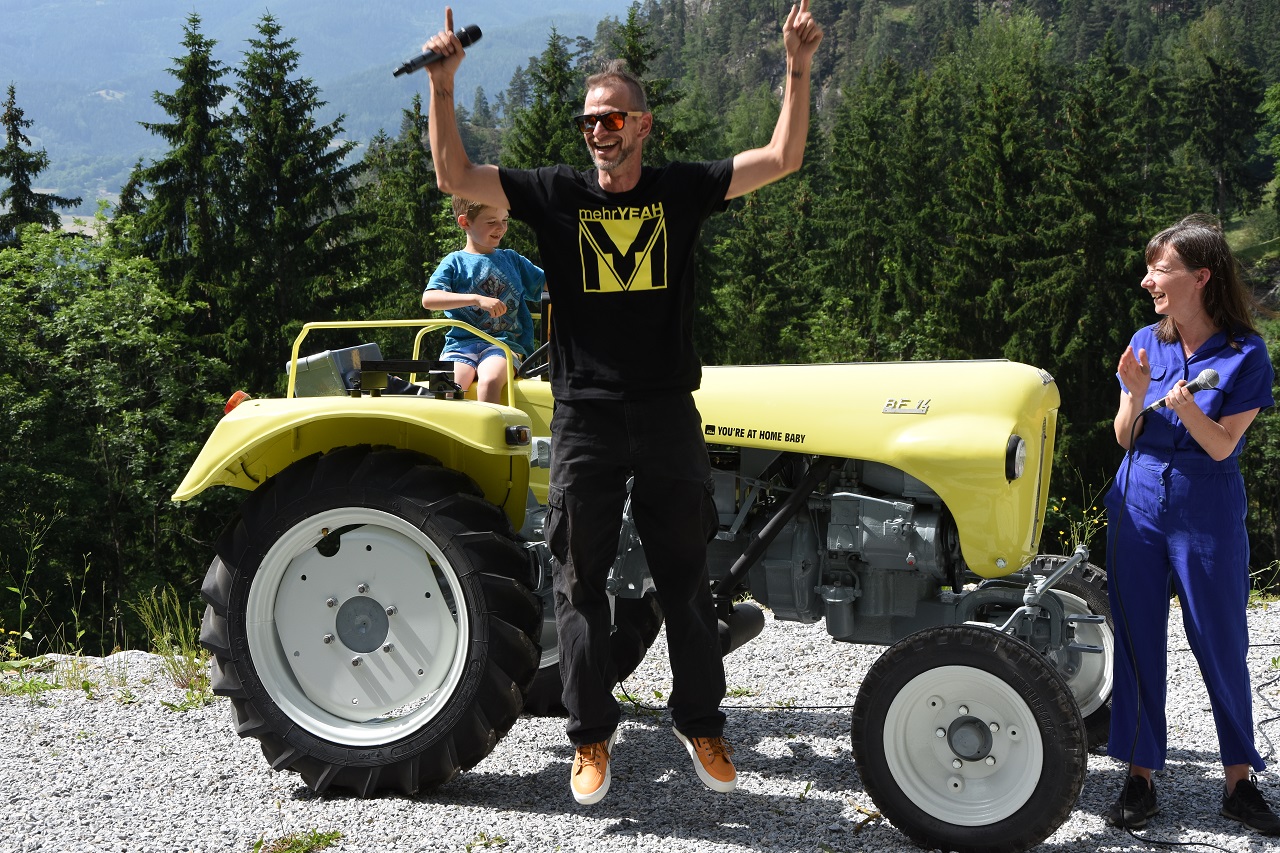 Familie Hagemann vor ihrem FM4-Traktor, Andreas Hagemann hüpft in die Luft vor Freude