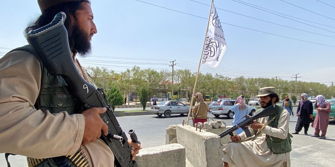 Taliban fighters stand guard at an entrance gate outside the Interior Ministry in Kabul on August 17, 2021