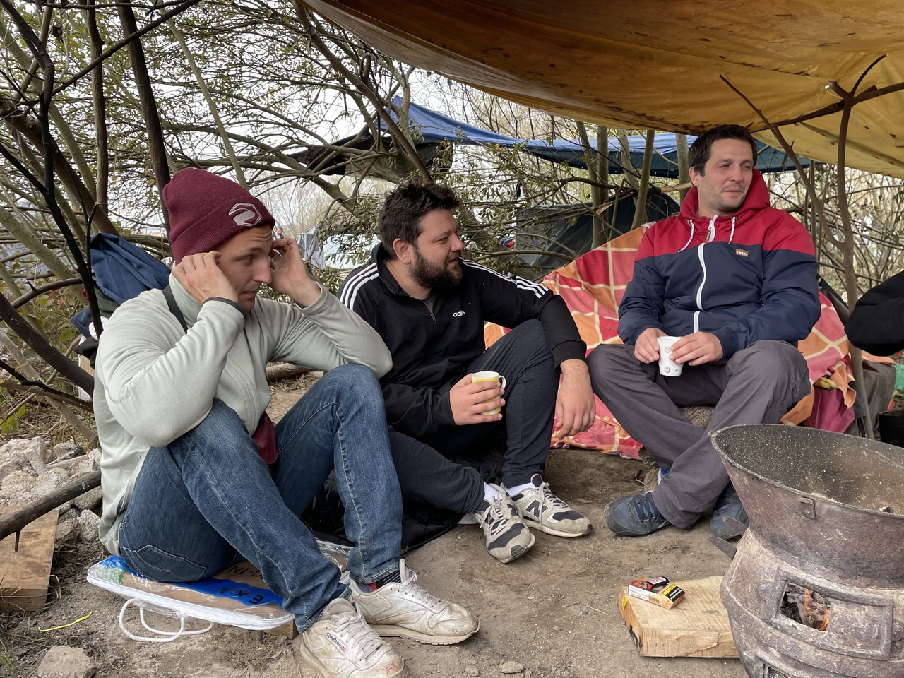 Kid Pex, Kreiml und Roli vom Label Honigdachs sitzen unter einem Zelt